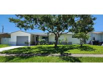 Charming single-story home with a well-maintained lawn and mature tree providing ample shade at 1583 Eunice Ln, Clearwater, FL 33756