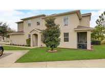 Charming townhouse featuring a well-manicured lawn and covered entryway at 1976 Marlington Way, Clearwater, FL 33763