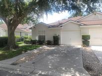 Charming single-story home with a well-maintained lawn and attached one-car garage at 21544 Clubside Loop, Lutz, FL 33549