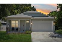 Charming single-Gathering home featuring a two-car garage, welcoming front porch, and manicured lawn at 3114 E 21St Ave, Tampa, FL 33605