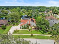 Stunning aerial view of a well-maintained home featuring mature landscaping and a serene pond at 4118 Carrollwood Village Dr, Tampa, FL 33618