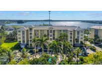 Beautiful condominium building with a shared pool, palm trees, and marina views in a waterfront community at 423 150Th Ave # 1501, Madeira Beach, FL 33708