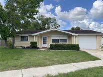 Charming single-story home with a well-maintained lawn and mature trees in a residential neighborhood at 5507 Casino Dr, Holiday, FL 34690