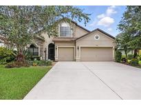 Charming two-story home with a three car garage, stone accents, and well-manicured lawn at 5962 Lexington Dr, Parrish, FL 34219