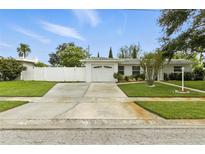Charming single-story home with well-maintained lawn, fenced yard, and a spacious driveway leading to a one-car garage at 6119 31St N Ave, St Petersburg, FL 33710