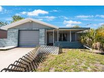 Charming single-story home featuring a garage and a welcoming front porch at 6834 Mesa Verde St, Port Richey, FL 34668