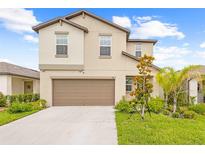 Charming two-story home with a well-manicured lawn, two-car garage, and a welcoming facade at 81 Rain Lily Ave, Spring Hill, FL 34609
