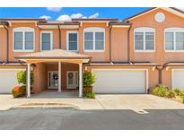 Charming townhouse with a two-car garage and lovely landscaping under a bright blue sky at 829 Date Palm Ln, St Petersburg, FL 33707