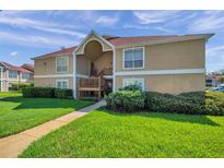 Inviting tan condo building featuring well-maintained landscaping and a welcoming walkway at 9481 Highland Oak Dr # 806, Tampa, FL 33647