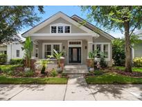 Charming home featuring manicured landscaping, neutral paint, and a welcoming covered porch entry at 10021 Brompton Dr, Tampa, FL 33626