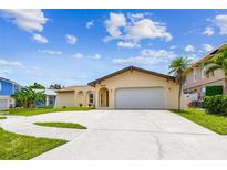 Charming single-story home featuring a well-manicured lawn, neutral paint, and a spacious driveway with palm tree at 12476 81St Ct, Seminole, FL 33772