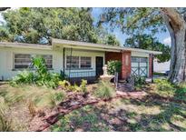 Charming home featuring lush landscaping, quaint fountain, and a delightful bridge walkway at 1530 Erin Ln, Clearwater, FL 33755
