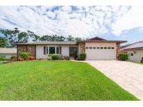 Charming single-story home featuring a lush green lawn and stone accents at 2174 Kent Ave, Clearwater, FL 33764
