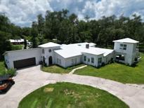 Stunning exterior view of this unique home with a pristine white roof and charming architectural details at 21921 Us Highway 98, Dade City, FL 33523
