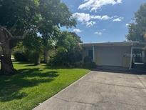 Charming single-story home with a well-maintained lawn and a spacious driveway leading to an attached garage at 2200 Palmetto Dr, Clearwater, FL 33763