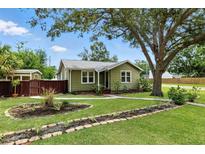Charming single story home showcasing a well-manicured lawn, landscaping, and mature trees at 6301 Hobson Ne St, St Petersburg, FL 33702