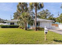 Charming single-story home with well-manicured lawn, palm trees, and a light blue front door at 8200 31St N Ter, St Petersburg, FL 33710