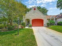 Charming single-story home with a bright red garage door and well-maintained lawn and landscaping at 8336 Monaco Dr # A, Port Richey, FL 34668