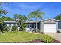 Charming single story home with a manicured lawn, tropical landscaping, and an attached garage in a desirable neighborhood at 8848 56Th N Way, Pinellas Park, FL 33782