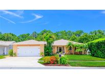 Charming one-story home with a lush, green front yard and lovely landscaping, including palm trees at 11116 118Th St, Seminole, FL 33778