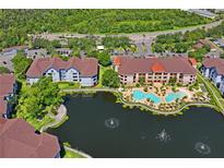 Stunning aerial view of resort-style condo community with pool, landscaping, and beautiful water features at 1640 Villa Capri Cir # 206, Odessa, FL 33556