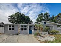 Charming single-story home with a well-maintained lawn, blue front door, and updated windows at 310 4Th Ave. Southwest, Ruskin, FL 33570
