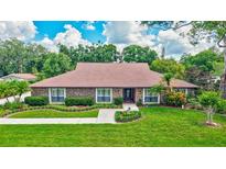 Charming brick home with well-manicured lawn, trimmed shrubs, and beautiful landscaping at 3923 Hudson Ln, Tampa, FL 33618