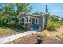 Charming bungalow with a screened front porch, brick accents, and a well-maintained yard at 917 W Idlewild Ave, Tampa, FL 33604