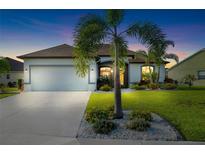 Charming single-story home with a well-manicured lawn and inviting curb appeal at dusk at 12830 24Th Street E Cir, Parrish, FL 34219