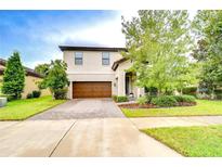 Charming home featuring a meticulously manicured front lawn and a beautiful paver driveway leading to a two-car garage at 13118 Payton St, Odessa, FL 33556