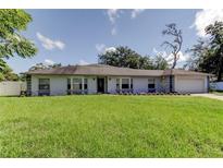 Charming single-story home featuring a manicured lawn and inviting curb appeal on a sunny day at 1402 Provincetown Cir, Lutz, FL 33549