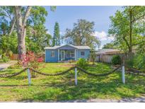 Charming blue bungalow with a beautifully landscaped yard and unique rope fence at 1912 E 97Th Ave, Tampa, FL 33612