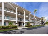 Three story condo building with palm trees and well-maintained landscaping at 211 Pasadena N Ave # 109, St Petersburg, FL 33710