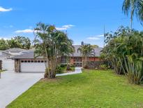 Charming single-story home with mature landscaping, a spacious lawn, and a two-car garage at 2708 W Bird St, Tampa, FL 33614