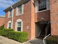 Brick condo building featuring shuttered windows, greenery, and covered stair access at 3535 41St S Ter # 219, St Petersburg, FL 33701