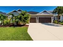 Beautiful home with a two-car garage, well-manicured lawn and tropical landscaping at 4906 Los Robles Ct, Palmetto, FL 34221