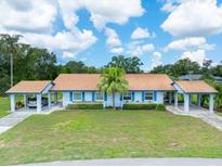 Charming single Gathering home featuring a well-manicured lawn, mature trees, and a light blue exterior at 511 Foxglove Cir # B, Sun City Center, FL 33573
