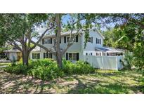 Two-story home with black shutters and lush, mature landscaping around the perimeter and backyard at 6301 13Th N Ave, St Petersburg, FL 33710