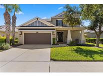 Charming home with a well-manicured lawn, a welcoming entrance, and a two-car garage at 9275 Bella Vita Cir, Land O Lakes, FL 34637