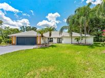 Charming single-story home with a manicured lawn and mature palm trees, creating an inviting curb appeal at 13710 Westshire Dr, Tampa, FL 33618