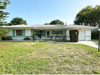 Charming single-story home with a well-maintained lawn, mature trees, and inviting curb appeal at 1448 Temple St, Clearwater, FL 33756