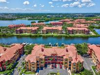 Aerial view of waterfront community with terracotta roofs and lush landscaping in a serene setting at 2733 Via Cipriani # 830B, Clearwater, FL 33764