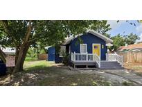 Charming blue home featuring a bright yellow door and a cozy front porch at 305 E Adalee St, Tampa, FL 33603