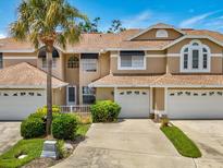 Charming multi-level townhome with attached garages, mature palm tree and meticulously maintained landscaping at 3077 Branch Dr, Clearwater, FL 33760