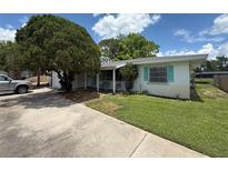 Charming single-story home featuring a well-manicured lawn, mature tree, and screened front porch at 4641 Carson Ne St, St Petersburg, FL 33703