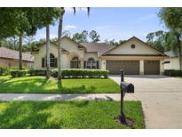 Charming home with a three-car garage, manicured lawn, and neat landscaping at 5360 Karlsburg Pl, Palm Harbor, FL 34685