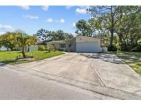 Charming single-story home featuring a two-car garage, mature trees, and a well-manicured lawn at 5998 8Th S St, St Petersburg, FL 33705