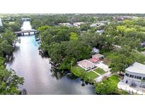 Stunning aerial view of the home nestled on the river, surrounded by lush greenery and beautiful landscaping at 8001 N Highland Ave, Tampa, FL 33604