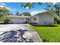 Charming single-story home featuring a well-manicured lawn and a two-car garage on a sunny day at 917 Pineview Ave, Clearwater, FL 33756