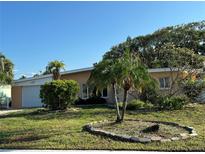 Charming single-story home with well-maintained lawn and mature trees, and a one car garage at 103 9Th St, Belleair Beach, FL 33786